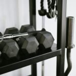 Close-up of gym equipment including dumbbells on a storage rack, perfect for fitness-themed uses.